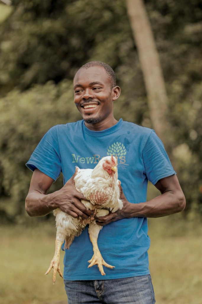 Một nông dân Haiti đang ôm một con gà tại New Roots, Cap-Haitien, Haiti, hồi tháng 04/2024. (Ảnh: Alexis Wood-Ally Julien/New Roots)