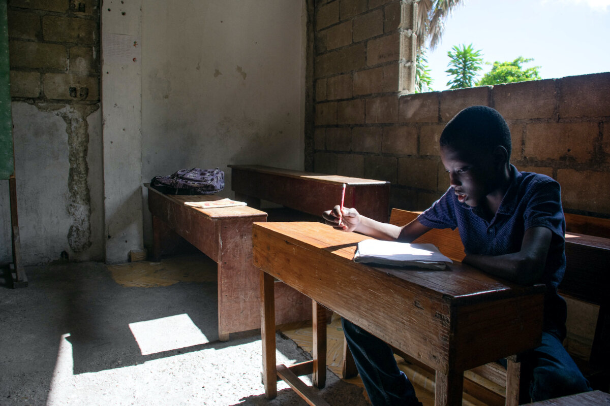 Một học sinh làm bài trên lớp trong ngày đầu tiên ngôi trường mở lại ở Port-au-Prince, Haiti, hôm 29/04/2024. Các trường học bị đóng cửa sau một vụ tấn công trí mạng của băng đảng vào nhà tù chính của thủ đô khiến hàng ngàn tù nhân trốn thoát trong đêm, hôm 03/03/2024. (Ảnh: Clarens Siffroy/AFP qua Getty Images)