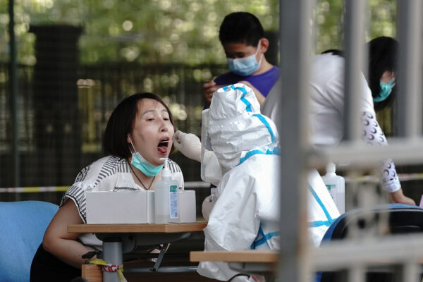 Nhân viên y tế lấy mẫu xét nghiệm từ một cư dân tại trạm thử nghiệm COVID-19 ở Bắc Kinh vào ngày 30 tháng 6 năm 2020. (Ảnh Lintao Zhang / Getty Images)