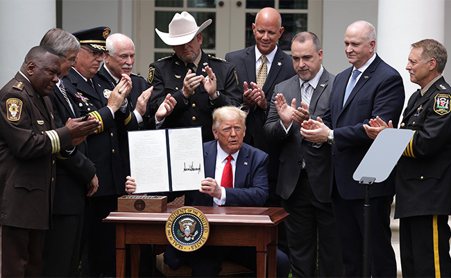Các quan chức ngành hành pháp hiện diện xung quanh TT Donald Trump trong buổi ký ban hành sắc lệnh hành pháp “chính sách an toàn cộng đồng” tại Vườn Hồng- Toà Bạch Ốc ngày 16/6.