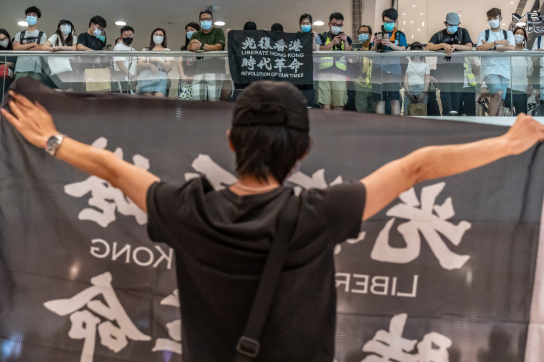 Người biểu tình chống chính phủ đeo khẩu trang, cầm băng-rôn với câu khẩu hiệu “quang phục Hương Cảng, thời đại cách mạng của chúng ta” trong một cuộc biểu tình tại một trung tâm mua sắm ở Hong Kong, vào ngày 10/5/2020. (Anthony Kwan / Getty Images)