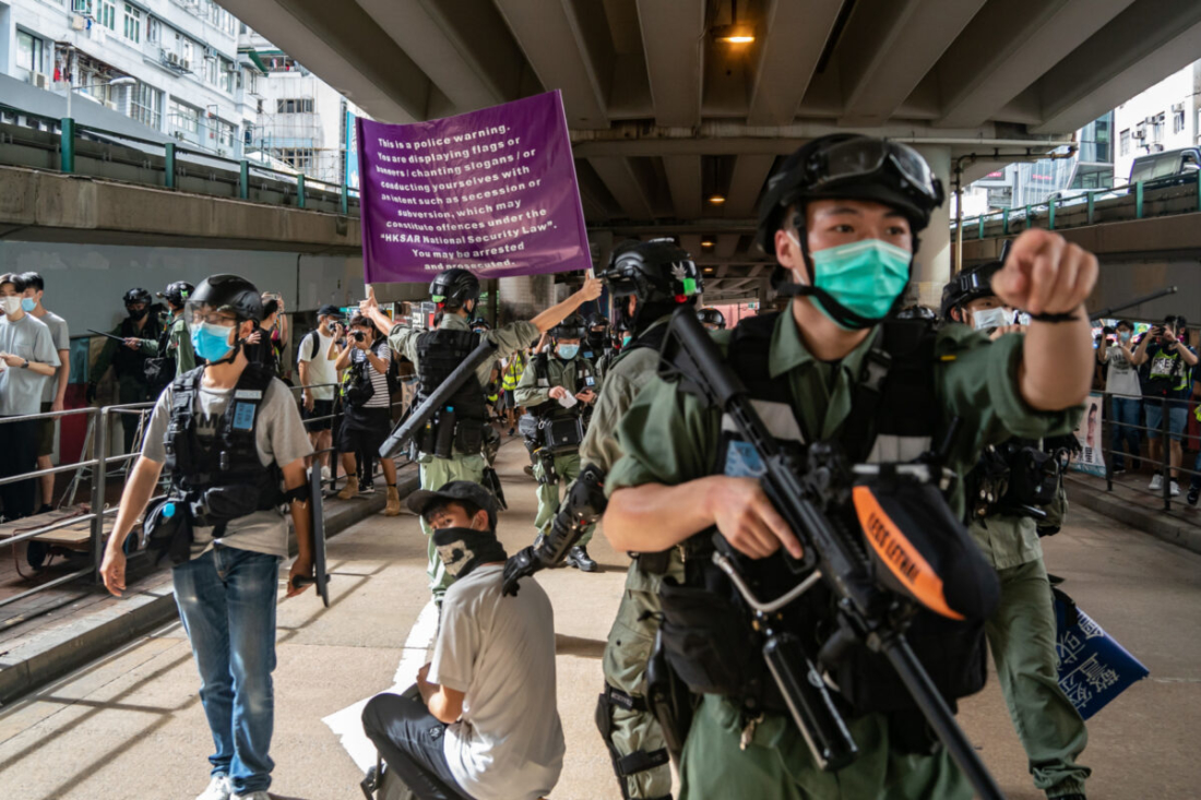 Cảnh sát chống bạo động bắt giữ một người đàn ông khi đang giương cờ cảnh báo trong một cuộc biểu tình chống lại luật an ninh quốc gia mới ở Hong Kong, vào ngày 1/7/2020. (Anthony Kwan / Getty Images)