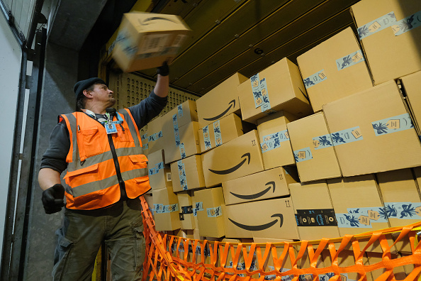 Một công nhân đang chất các gói hàng lên một chiếc xe tải tại một trung tâm đóng gói của Amazon vào ngày 28 tháng 11 năm 2019 tại Br Dieselang, Đức. (Ảnh: Sean Gallup/Getty Images)