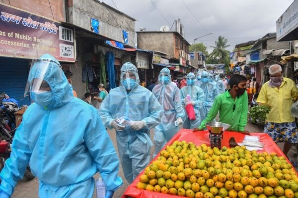 Các nhân viên y tế cùng với nhóm tình nguyện viên Rashtriya Swayamsevak Sangh (RSS) của Ấn Độ giáo, đi bộ qua một khu chợ để kiểm tra y tế  từng nhà trong một khu ổ chuột, nhằm chống lại sự lây lan của virus viêm phổi Vũ Hán ở Mumbai, Ấn Độ, vào ngày 17/6/2020. (Getty)