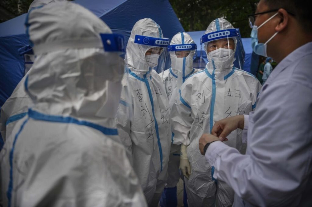 Một bác sĩ Trung Quốc hướng dẫn các y tá mặc đồ bảo hộ trước khi thực hiện xét nghiệm axit nucleic cho cư dân tại địa điểm xét nghiệm của chính phủ tại Bắc Kinh, Trung Quốc ngày 22/06/2020. (Getty)