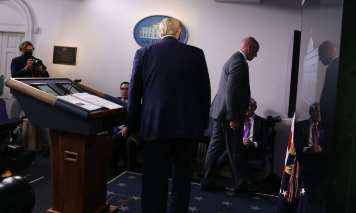 Một nhân viên mật vụ Hoa Kỳ yêu cầu Tổng thống Donald Trump rời khỏi phòng họp báo sau một vụ nổ súng gần Tòa Bạch Ốc ở Hoa Thịnh Đốn vào ngày 10/8/2020. (Alex Wong/Getty Images qua The Epoch Times)