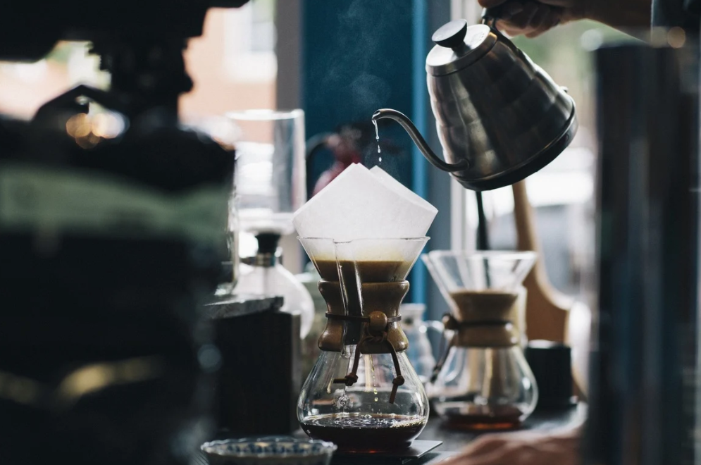 Cha của anh phục vụ cà phê cho một vị khách bên ngoài cửa hàng. Một chiếc mũ "Làm cho nước Mỹ vĩ đại trở lại" được đội trên đầu một bức tượng gỗ. Đằng sau nó là một bức ảnh đóng khung hình Tổng thống Donald Trump...