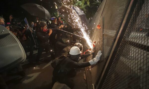 Người biểu tình cắt hàng rào thép trong một cuộc biểu tình Black Lives Matter tại Tòa án Mark O. Hatfield ở Portland, Ore., vào ngày 24/7/2020. (Ảnh Marcio Jose Sanchez / AP)