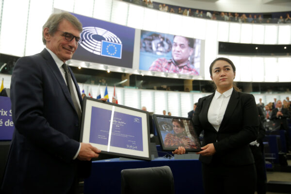 Chủ tịch Nghị viện Châu Âu David-Maria Sassoli đứng cạnh Jewher Ilham, con gái của Ilham Tohti, nhà kinh tế và nhà hoạt động nhân quyền người Duy Ngô Nhĩ, đang cầm một bức chân dung của cha mình trong lễ trao Giải thưởng Sakharov EU 2019 cho ông tại Nghị viện Châu Âu ở Strasbourg, Pháp, vào ngày 18/12/2019. (Ảnh Vincent Kessler / Reuters)