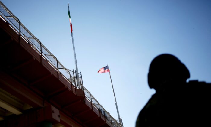 Một lá cờ Hoa Kỳ và lá cờ Mexico trên cây cầu biên giới quốc tế giữa El Paso, Hoa Kỳ và Ciudad Juarez, Mexico, vào ngày 9 tháng 7 năm 2019. (Daniel Becerril / Reuters qua The Epoch Times)