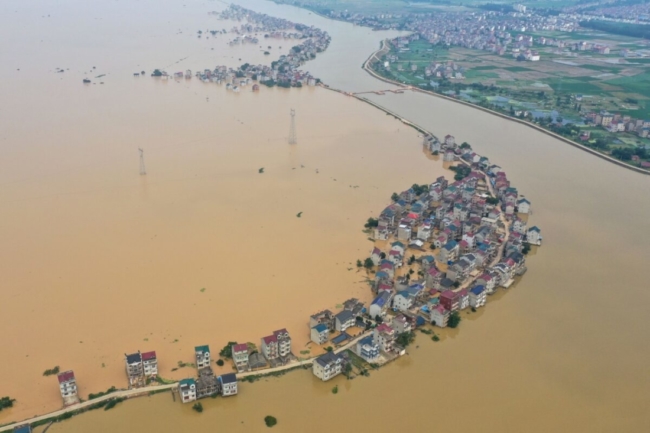 <em>Ảnh chụp từ trên cao cho thấy đường phố ngập nước và các tòa nhà bị ngập trong lũ sau khi một con đập bị vỡ do lũ lụt ở Cửu Giang, Trung Quốc vào ngày 13/7/2020. (Ảnh: STR / AFP qua Getty Images)</em>