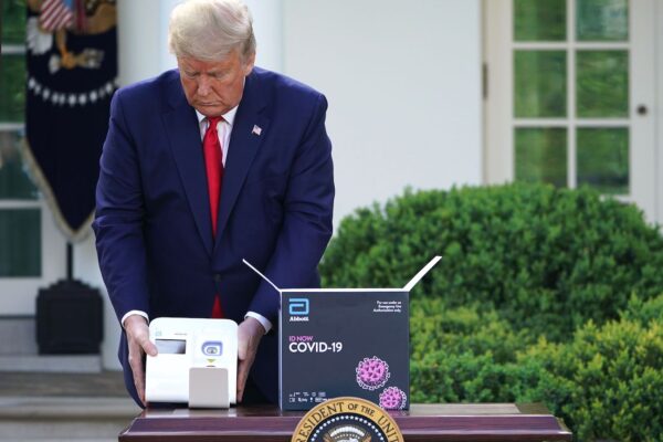 Tổng thống Donald Trump tổ chức một cuộc kiểm tra kit thử nghiệm xác định kháng thểCOVID-19 của Phòng thí nghiệm Abbott trong Vườn Hồng, Nhà Trắng, Washington, vào ngày 30 tháng 3 năm 2020. (Ảnh Mandel Ngân / AFP / Getty Images)