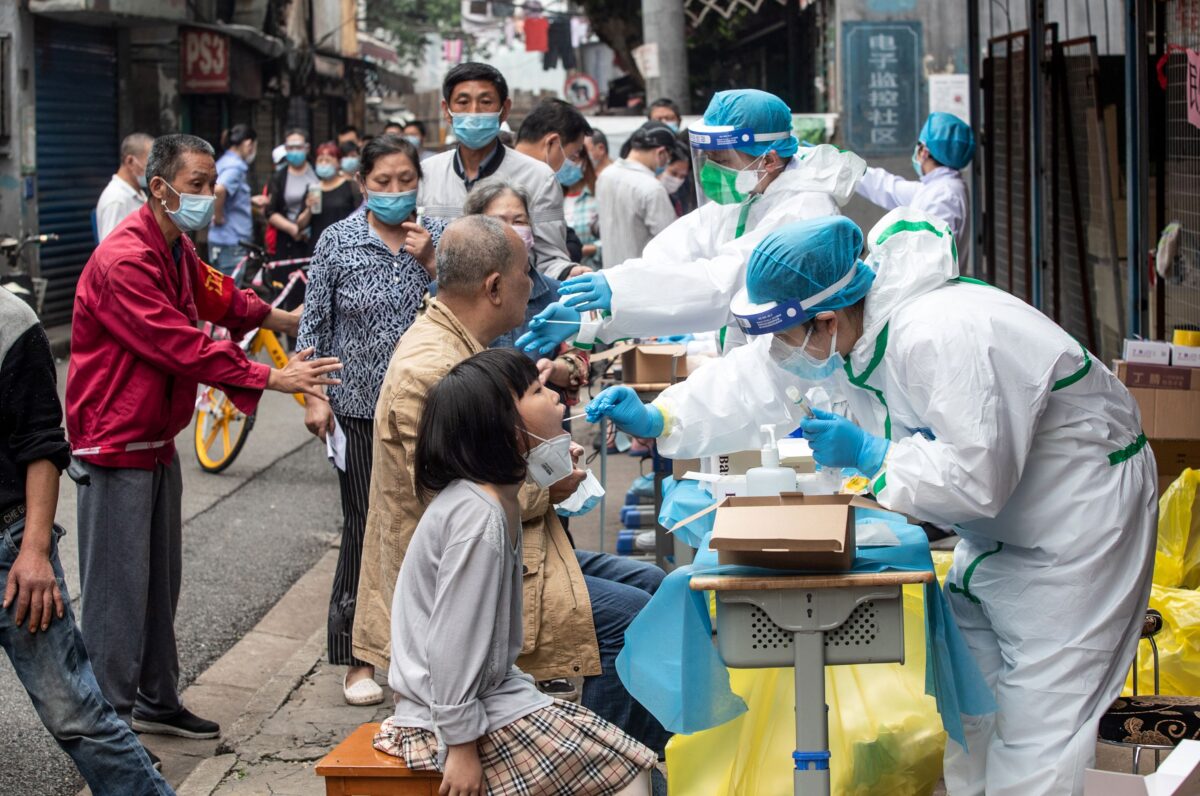 Các nhân viên y tế lấy mẫu tăm bông từ người dân để xét nghiệm COVID-19, ở thành phố Vũ Hán thuộc tỉnh Hồ Bắc, miền trung Trung Quốc vào ngày 15/5/2020. (Ảnh STR/AFP qua Getty Images)