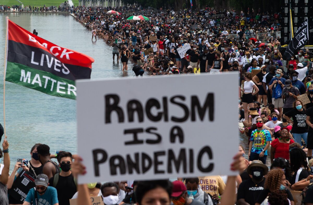 Những người biểu tình treo cờ Black Lives Matter để ủng hộ phong trào Tháng ba cam kết, được tổ chức bởi Mục sư Al Sharpton tại Hoa Thịnh Đốn ngày 28/8/2020. (Ảnh: Roberto Schmidt/AFP/Getty qua The Epoch Times)