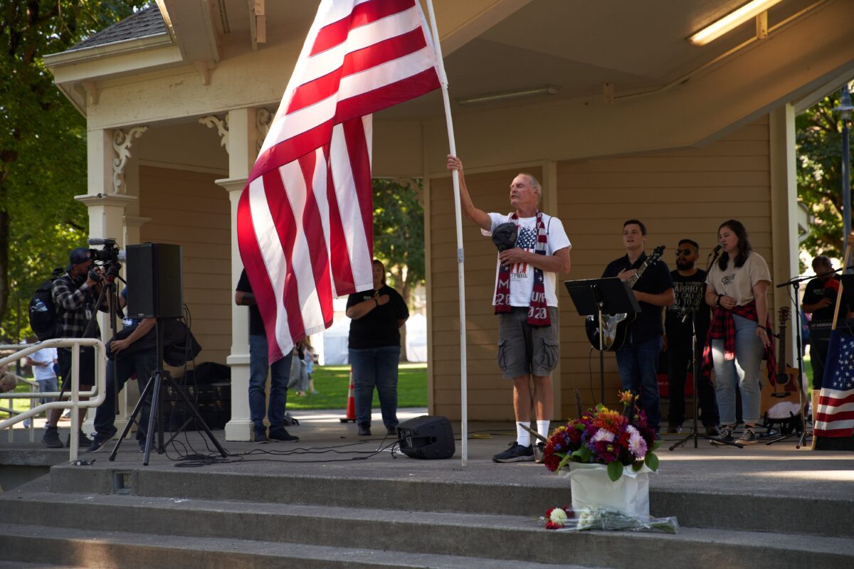 Một người đàn ông phất cờ Mỹ trong khi hát quốc ca khi các thành viên và những người ủng hộ tổ chức Cầu nguyện Yêu nước tập trung tại Công viên Esther Short để tưởng niệm Aaron Danielson ở Vancouver, bang Washington, vào ngày 5/9/2020. (Ảnh: Allison Dinner/AFP/Getty qua The Epoch Times)