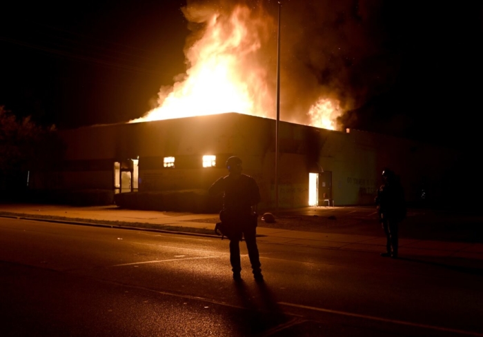 Các nhân viên cảnh sát đang quan sát tòa nhà của Bộ phận Cải tạo Cộng đồng bị ngọn lửa nhấn chìm trong cuộc bạo động ở Kenosha, Wis., ngày 24/8/2020. (Ảnh  Stephen Maturen/ Reuters)
