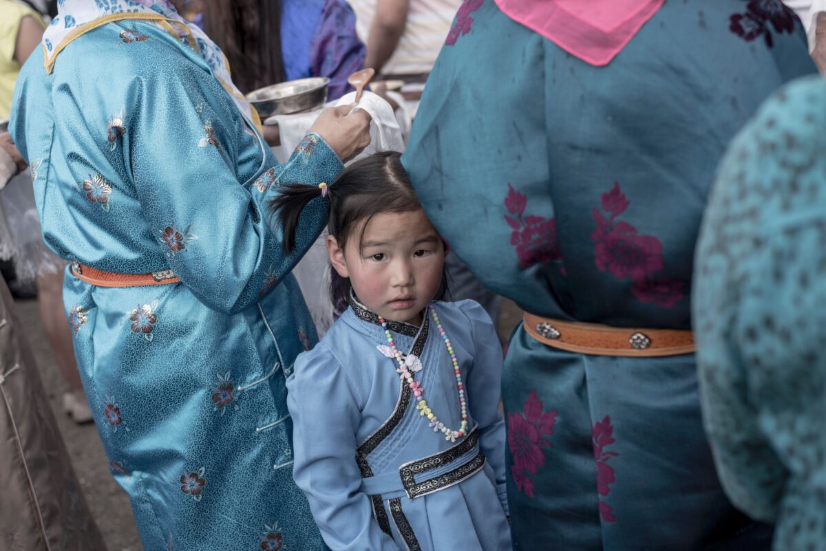 Một bé gái mặc trang phục truyền thống của Mông Cổ cùng mẹ đợi để lắng nghe bài phát biểu của ứng cử viên tranh cử tổng thống Mông Cổ Battulga Khaltmaa đến từ Đảng Dân chủ Mông Cổ tại Ulan Bator, vào ngày 23 tháng 6 năm 2017. (Ảnh Fred Dufour / AFP / Getty Images)