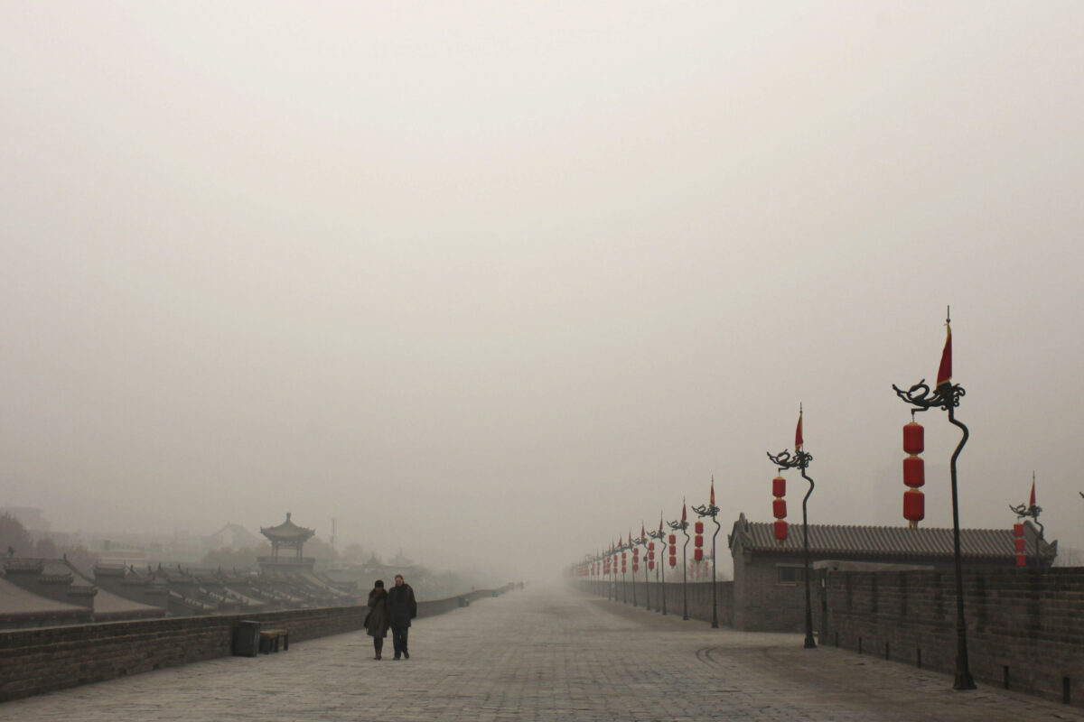 Du khách bước đi trên bức tường thành khi sương khói dày đặc bao trùm thành phố ở Tây An, Trung Quốc, vào ngày 18/12/2013. (Ảnh Getty Images)