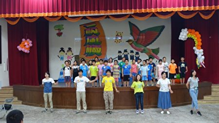 Trợ lý đội phụ đạo hướng dẫn bọn trẻ cùng hát bài ca của hội trại. (Giản Nguyên Lương / Epoch Times)