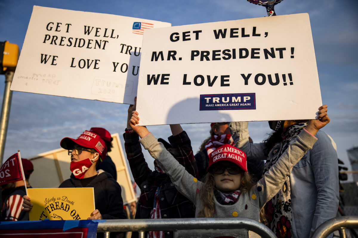 Những đứa trẻ em giơ những tấm biển chúc Tổng thống Donald Trump có sức khỏe tốt bên ngoài Trung tâm Y tế Quân đội Quốc gia Walter Reed sau khi Tổng thống được đưa vào điều trị COVID-19 ở Bethesda, Maryland, vào ngày 4/10/2020. (Ảnh Samuel Corum / Getty Images)