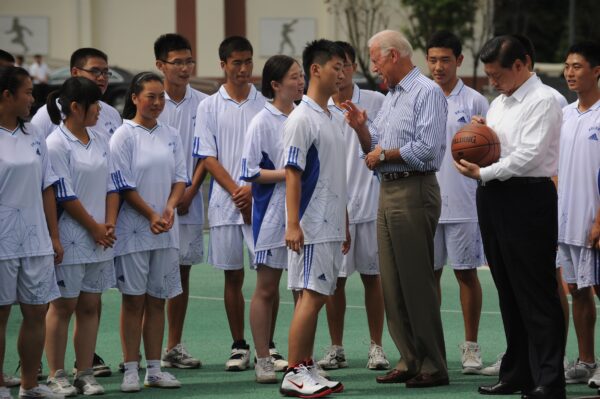 Phó Tổng thống Hoa Kỳ khi đó, ông Joe Biden (ở giữa-bên phải) nói chuyện với một học sinh khi Phó Chủ tịch Trung Quốc Tập Cận Bình (phải) ký tên trên một quả bóng rổ tại trường trung học Dujiangyan Qingchengshan bên ngoài Thành Đô ở tỉnh Tứ Xuyên, một tỉnh tây nam Trung Quốc vào ngày 21/8/2011. (Ảnh Peter Parks / AFP / Getty Images)