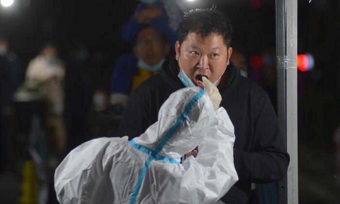 Một nhân viên y tế lấy tăm bông để xét nghiệm axit nucleic COVID-19 sau đợt bùng phát virus corona mới ở Thanh Đảo, tỉnh Sơn Đông, miền đông Trung Quốc vào ngày 13 tháng 10 năm 2020 (Ảnh STR / AFP qua Getty Images)