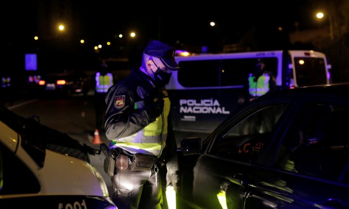 Một sỹ quan cảnh sát chờ đợi để kiểm tra tài liệu tại một trạm kiểm soát khi Madrid phong toả một phần do dịch bệnh COVID-19 vào ngày 2 tháng 10 năm 2020 (Ảnh Javier Barbancho / Reuters)