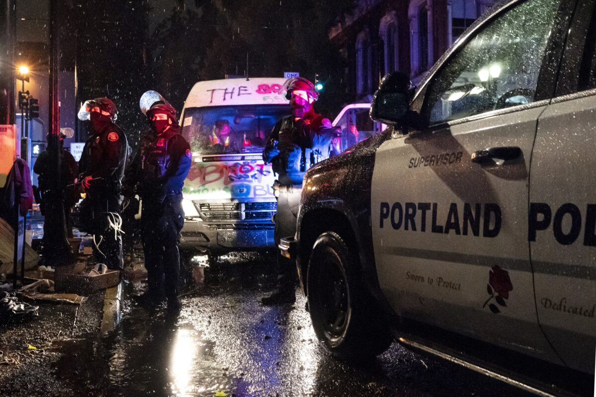 Cảnh sát bắt giữ hành khách của một chiếc xe tải có liên quan đến bạo loạn, ở Portland, Oregon, vào ngày 11/10/2020. (Ảnh Nathan Howard/Getty Images)
