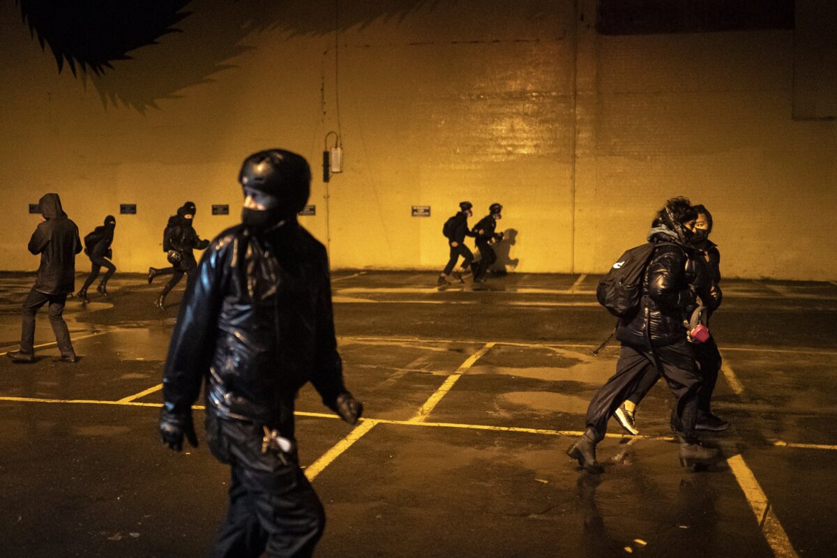 Mọi người chạy trốn khỏi các sĩ quan cảnh sát trong một cuộc bạo động ở Portland, Oregon, vào ngày 11/10/2020. (Ảnh Nathan Howard/Getty Images)