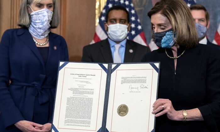 Speaker of the House Nancy Pelosi (D-Calif.) displays a signed article of impeachment against President Donald Trump at the U.S. Capitol in Washington on Jan. 13, 2021. (Stefani Reynolds/Getty Images) - bỏ phiếu luận tội TT Trump