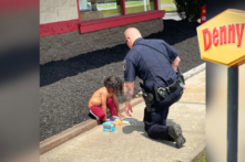 Bức ảnh cảm động ghi lại khoảnh khắc viên cảnh sát cúi người an ủi cậu bé vô gia cư