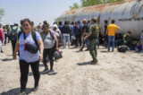 Một nhân viên Tuần tra Biên giới điều phối một nhóm lớn những người nhập cư bất hợp pháp ở gần Eagle Pass, Texas, hôm 20/05/2022. (Ảnh: Charlotte Cuthbertson/The Epoch Times)