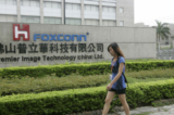 Một công nhân Trung Quốc đi ngang qua một nhà máy Foxconn trong một khu công nghiệp của thành phố Phật Sơn, tỉnh Quảng Đông phía nam Trung Quốc Hôm 17/06/2010. (Ảnh: STR/AFP/Getty Images)