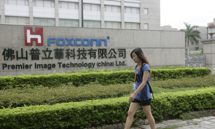 Một công nhân Trung Quốc đi ngang qua một nhà máy Foxconn trong một khu công nghiệp của thành phố Phật Sơn, tỉnh Quảng Đông phía nam Trung Quốc Hôm 17/06/2010. (Ảnh: STR/AFP/Getty Images)