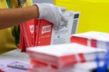 Một nhân viên bầu cử mở phong bì chứa các lá phiếu bầu qua thư cho cuộc bầu cử sơ bộ hôm 04/08 của tiểu bang Washington tại King County Elections ở Renton, Hoa Thịnh Đốn, vào ngày 03/08/2020. (Ảnh: Jason Redmond/AFP qua Getty Images)