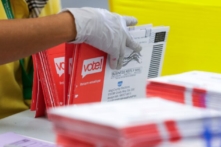 Một nhân viên bầu cử mở các bì thư chứa phiếu bầu qua thư trong một bức ảnh tư liệu. (Ảnh: Jason Redmond/AFP qua Getty Images)