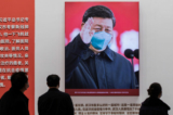 Bức ảnh chụp lãnh đạo Trung Quốc Tập Cận Bình đeo khẩu trang được trưng bày tại một trung tâm hội nghị trước đây được sử dụng làm bệnh viện dã chiến dành cho bệnh nhân ở Vũ Hán, Trung Quốc, vào ngày 15/01/2021. (Ảnh: Nicolas Asfouri/AFP qua Getty Images)
