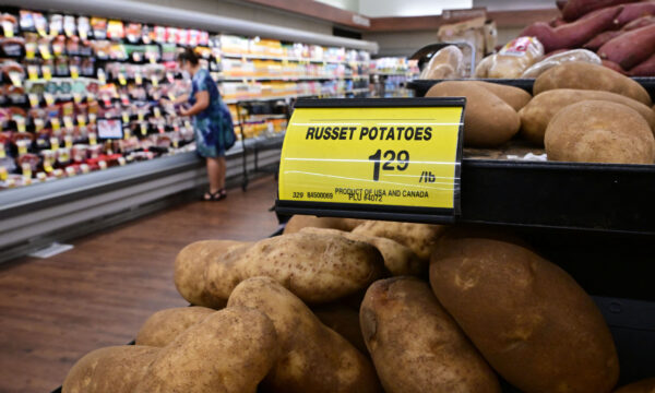 Một người mua hàng đi ngang qua tấm biển ghi giá mỗi pound khoai tây nâu tại một siêu thị ở Montebello, California, hôm 23/08/2022. (Ảnh: Frederic J. Brown/AFP qua Getty Images)