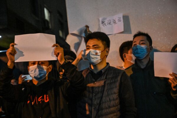 Người biểu tình cầm những tờ giấy trắng như một cách để phản đối khi tụ tập trên một con phố ở Thượng Hải hôm 27/11/2022. (ẢNh: Hector Retamal/AFP via Getty Images)
