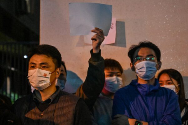 Người dân trưng ra những tờ giấy trắng như một cách để phản đối, tụ tập trên một con phố ở Thượng Hải hôm 27/11/2022, nơi diễn ra các cuộc biểu tình phản đối chính sách zero-COVID của Trung Quốc vào đêm trước khi xảy ra vụ hỏa hoạn chết người ở Ô Lỗ Mộc Tề (Urumqi), thủ phủ của vùng Tân Cương. (Ảnh: Hector Retamal/AFP qua Getty Images)