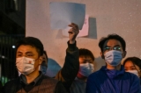 Mọi người giơ lên những tờ giấy trắng như một cách để phản đối, tập trung trên một con đường ở Thượng Hải hôm 27/11/2022, nơi các cuộc biểu tình phản đối chính sách zero COVID của Trung Quốc diễn ra vào đêm trước khi xảy ra vụ hỏa hoạn gây tử vong ở Urumqi, thủ phủ của vùng Tân Cương. (Ảnh: Hector Retamal/AFP qua Getty Images)