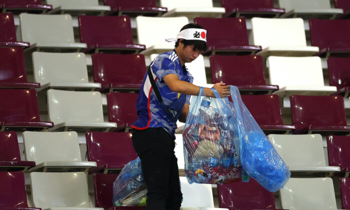 Một cổ động viên người Nhật dọn rác trên khán đài trong trận đấu Bảng E của FIFA World Cup Qatar 2022 giữa Đức và Nhật Bản tại sân vận động quốc tế Khalifa ở Doha, Qatar hôm 23/11/2022. (Ảnh: Alex Grimm/Getty Images)