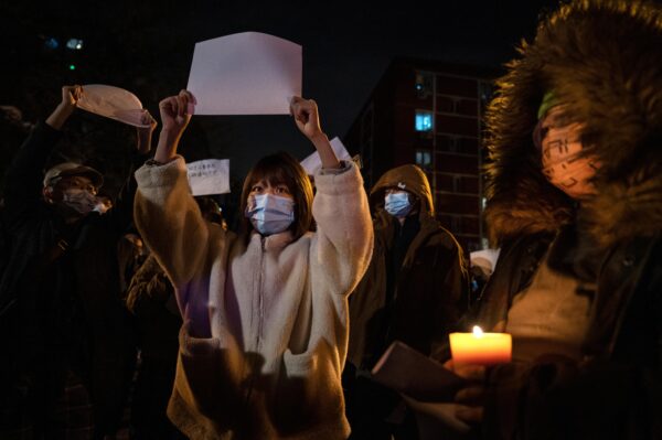 Người biểu tình giơ cao giấy trắng phản đối kiểm duyệt khi họ diễn hành trong cuộc biểu tình phản đối các biện pháp zero COVID nghiêm ngặt của Trung Quốc tại Bắc Kinh hôm 27/11/2022. (Ảnh: Kevin Frayer/Getty Images)