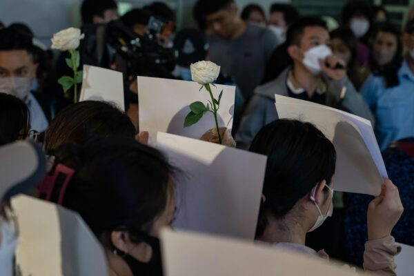 Mọi người cầm những tờ giấy trắng để phản đối các hạn chế COVID ở Trung Quốc đại lục khi công an dựng hàng rào trong một buổi cầu nguyện dưới ánh nến ở quận Trung (Trung Hoàn) ở Hồng Kông hôm 28/11/2022. (Ảnh: Anthony Kwan/Getty Images)
