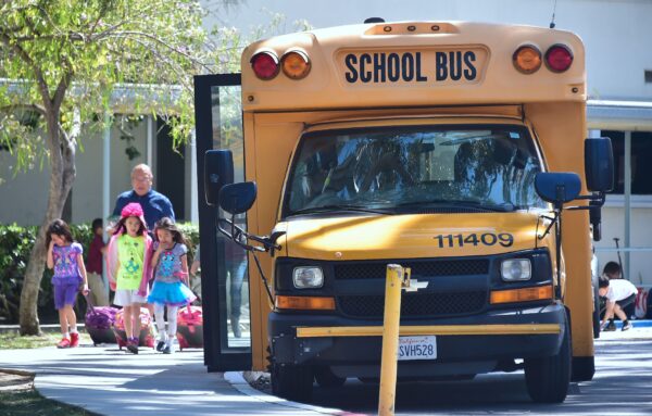 Trẻ em đi qua một chiếc xe buýt trường học ở Monterey Park, California, vào ngày 28/04/2017. (Ảnh: Frederic J. Brown/AFP qua Getty Images)