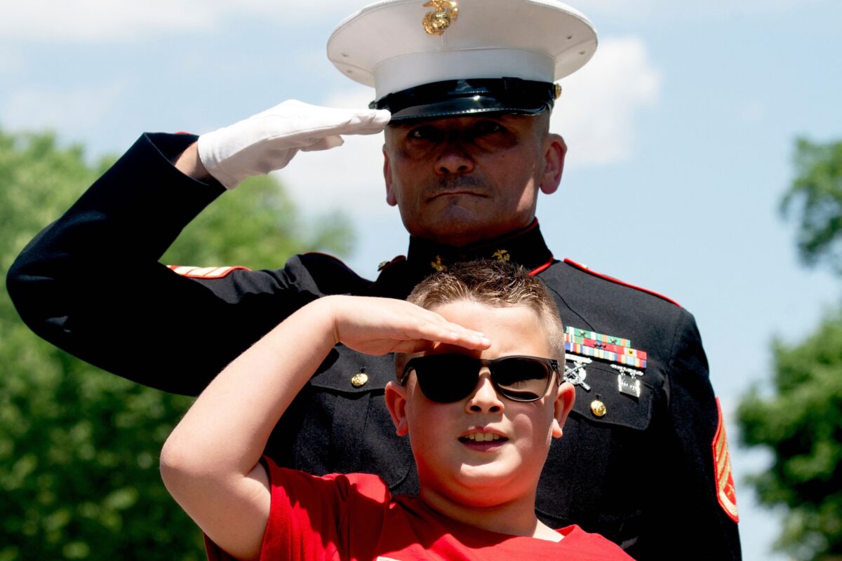 Jackson Leonard, cậu con trai 8 tuổi của một người lính Thủy quân Lục chiến Hoa Kỳ, chào khi người lái xe mô tô trong sự kiện Rolling to Remember lái xe ngang qua gần Đài tưởng niệm Lincoln ở Hoa Thịnh Đốn hôm 29/05/2022. (Ảnh: Stefani Reynolds/Getty Images)