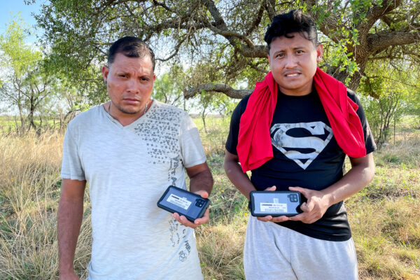 Hai công dân Nicaragua cầm điện thoại di động mà họ nhận được từ Lực lượng Tuần tra Biên giới trước khi được cho phép vào Hoa Kỳ, tại Quận Kinney, Texas, hôm 29/04/2022. (Ảnh: Charlotte Cuthbertson/The Epoch Times)