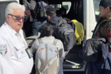 Một quan chức di trú Mexico đợi những người di cư được cơ quan quản lý Hoa Kỳ chấp thuận bước vào xe tải của ông để sẵn sàng vượt biên vào Hoa Kỳ qua một cảng nhập cảnh. (Ảnh: Đăng dưới sự cho phép của Todd Bensman/Trung tâm Nghiên cứu Nhập cư)