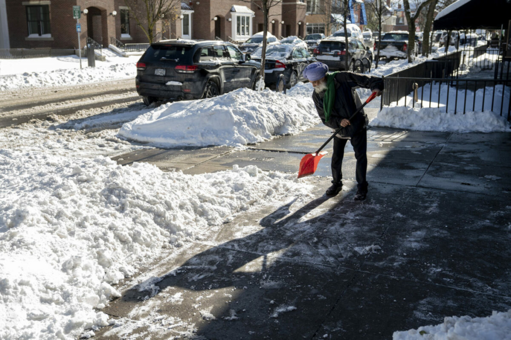 Ông Manjit Bath dọn sạch vỉa hè phủ đầy tuyết ở trước nhà hàng India Gate, sau hai ngày của trận tuyết hiệu ứng hồ trên Đại lộ Elmwood ở Buffalo, New York, hôm 20/11/2022. (Ảnh: Libby March/The Buffalo News qua AP)