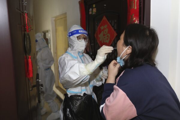 Một nhân viên y tế lấy mẫu dịch tỵ hầu cho một cư dân trong đợt xét nghiệm COVID-19 tận nhà ở Trịnh Châu, tỉnh Hà Nam, miền trung Trung Quốc hôm 01/11/2022. (Ảnh Chinatopix/qua AP)